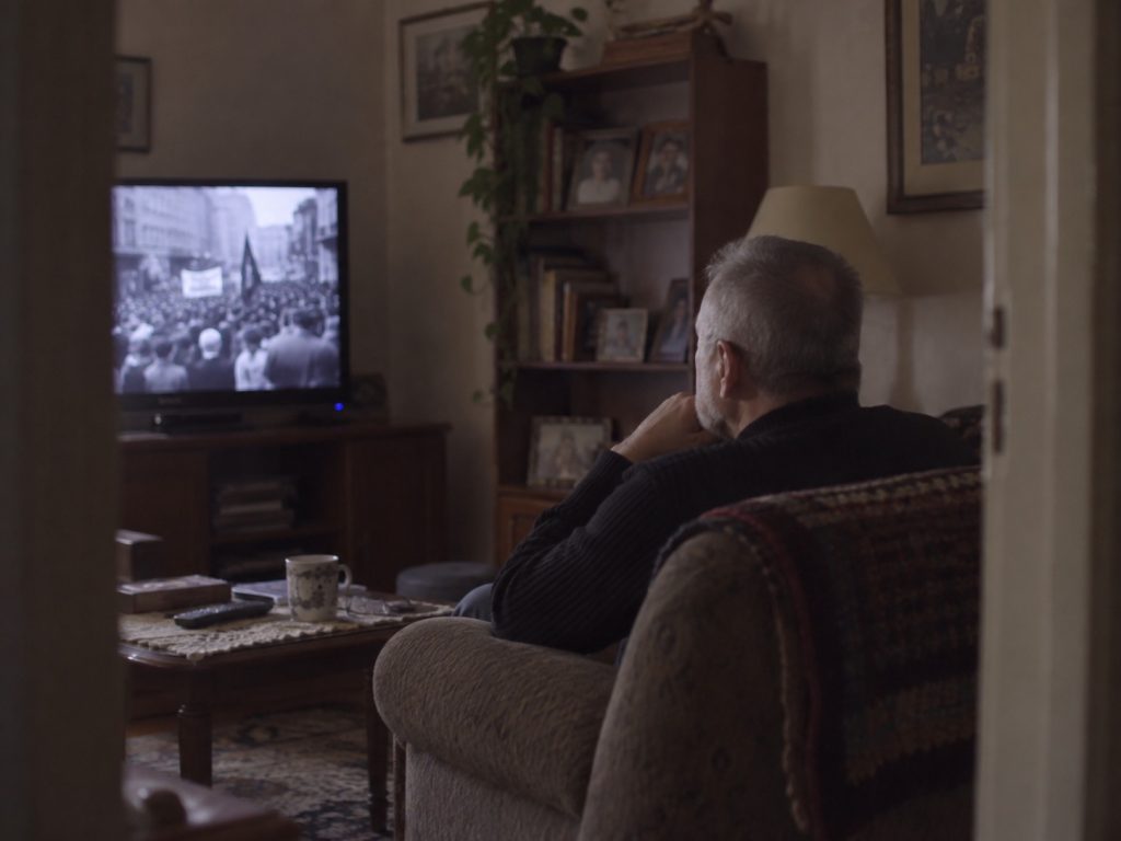 Hombre viendo La batalla de Chile de Patricio Guzmán en televisión